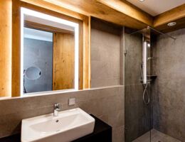 Moderne Sanitäranlagen mit Holz, viel Licht und großen Spiegeln